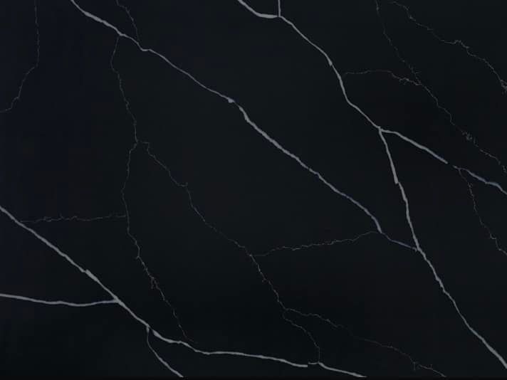 A close up of a black marble counter top with white veins