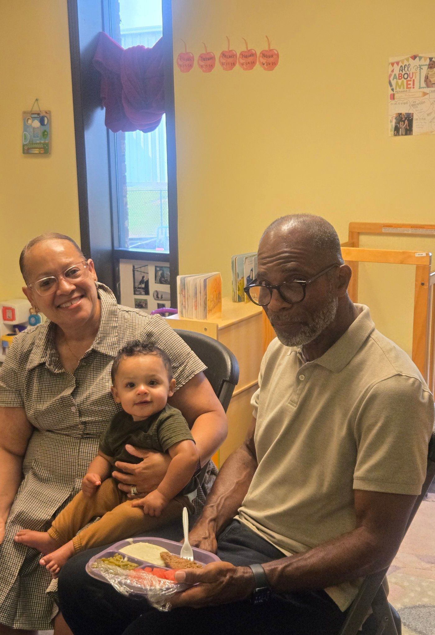 Woman holding a baby, man holding plate of food.