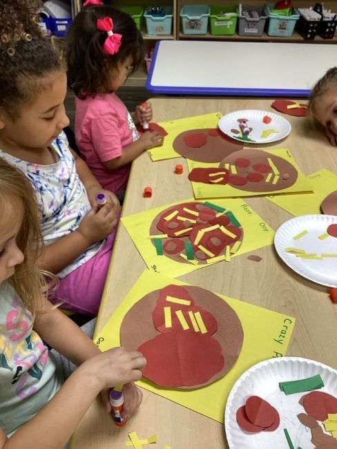 Children making pizza art with construction paper and glue.