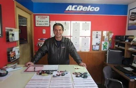 Man standing behind a counter in an auto parts store with AC Delco sign.