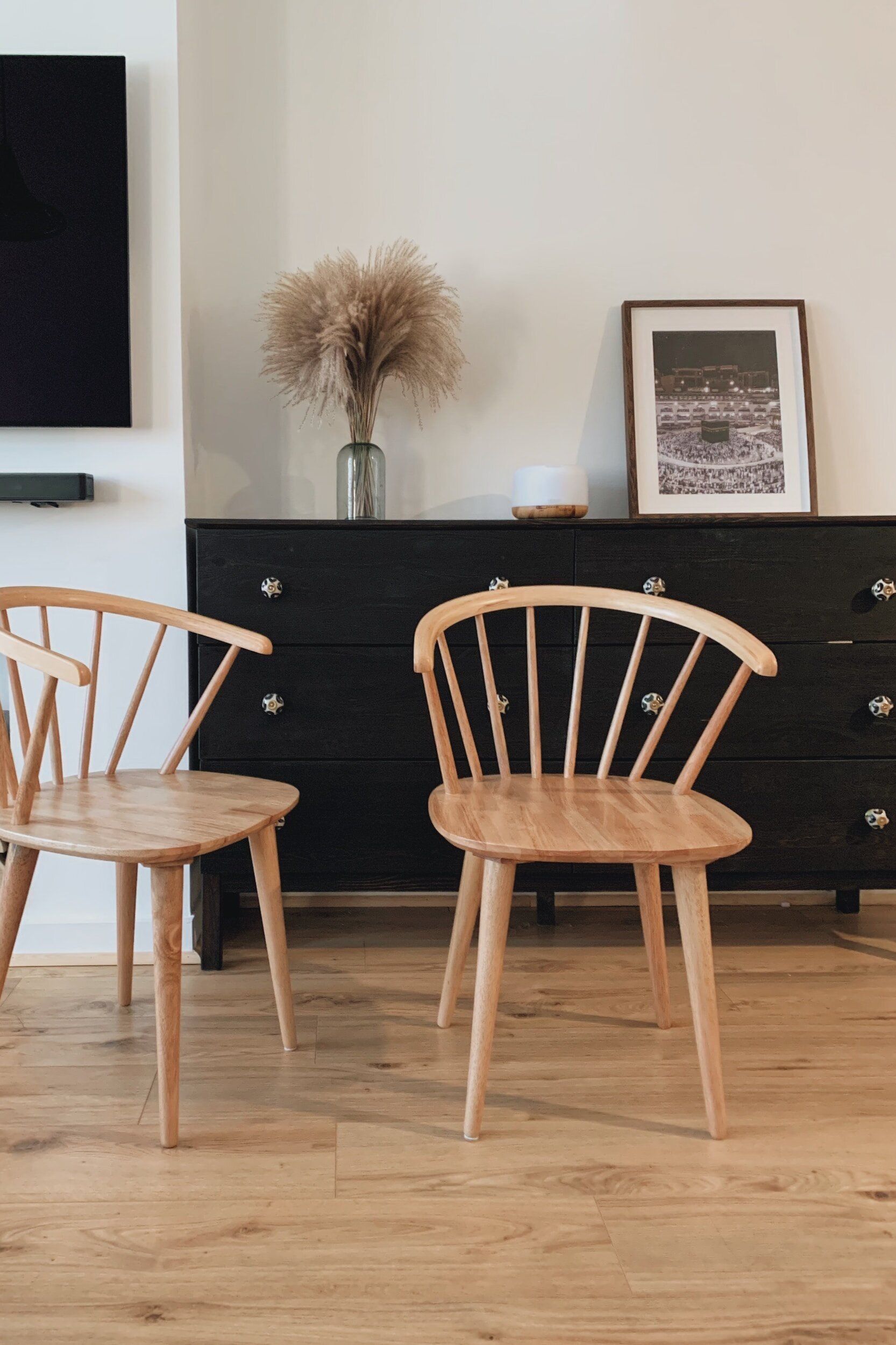 Two wooden chairs are sitting next to each other in a living room.