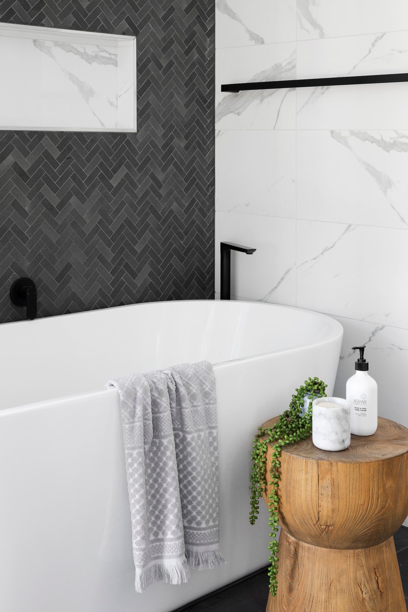 A bathroom with a bathtub and a wooden stool.