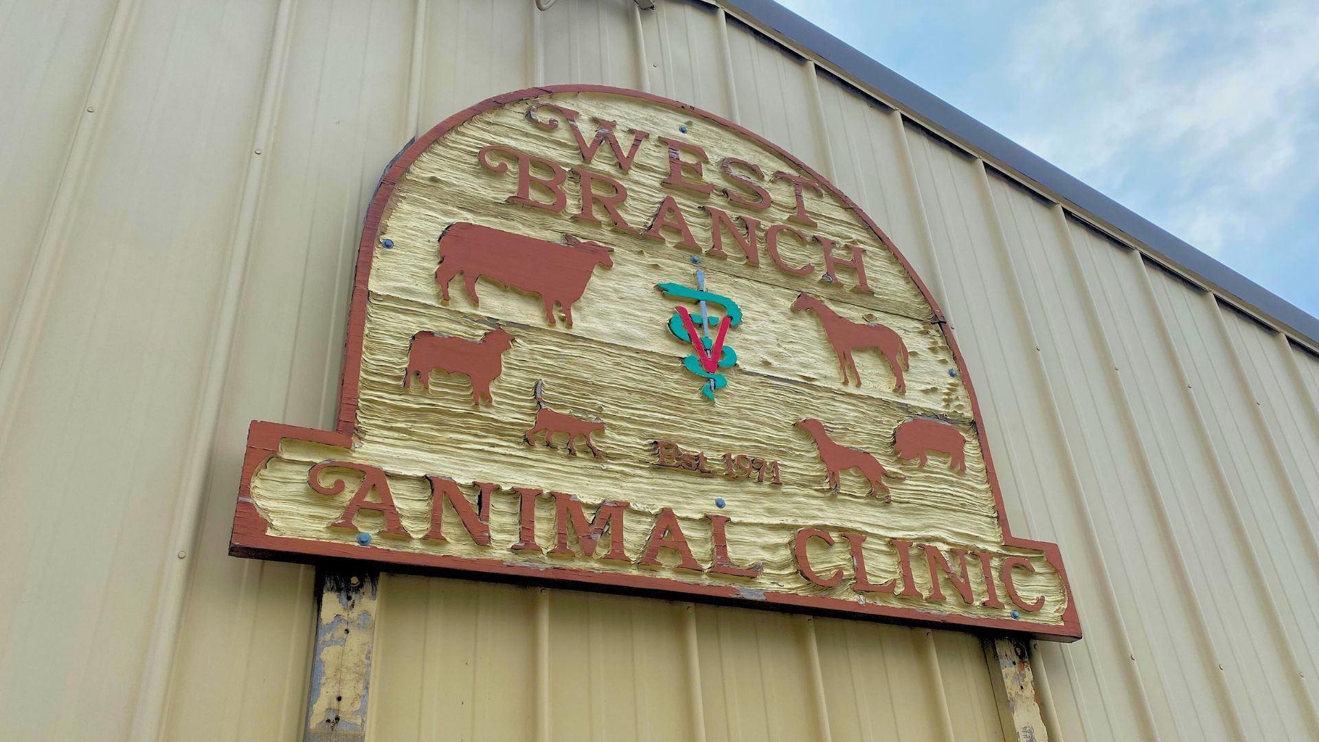 A sign on the side of a building that says West Branch Animal Clinic