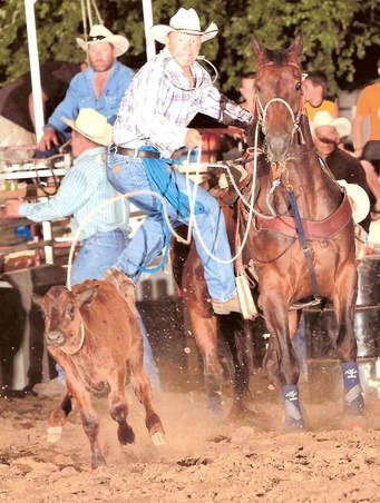 A man is riding a horse while another man is riding a bull.