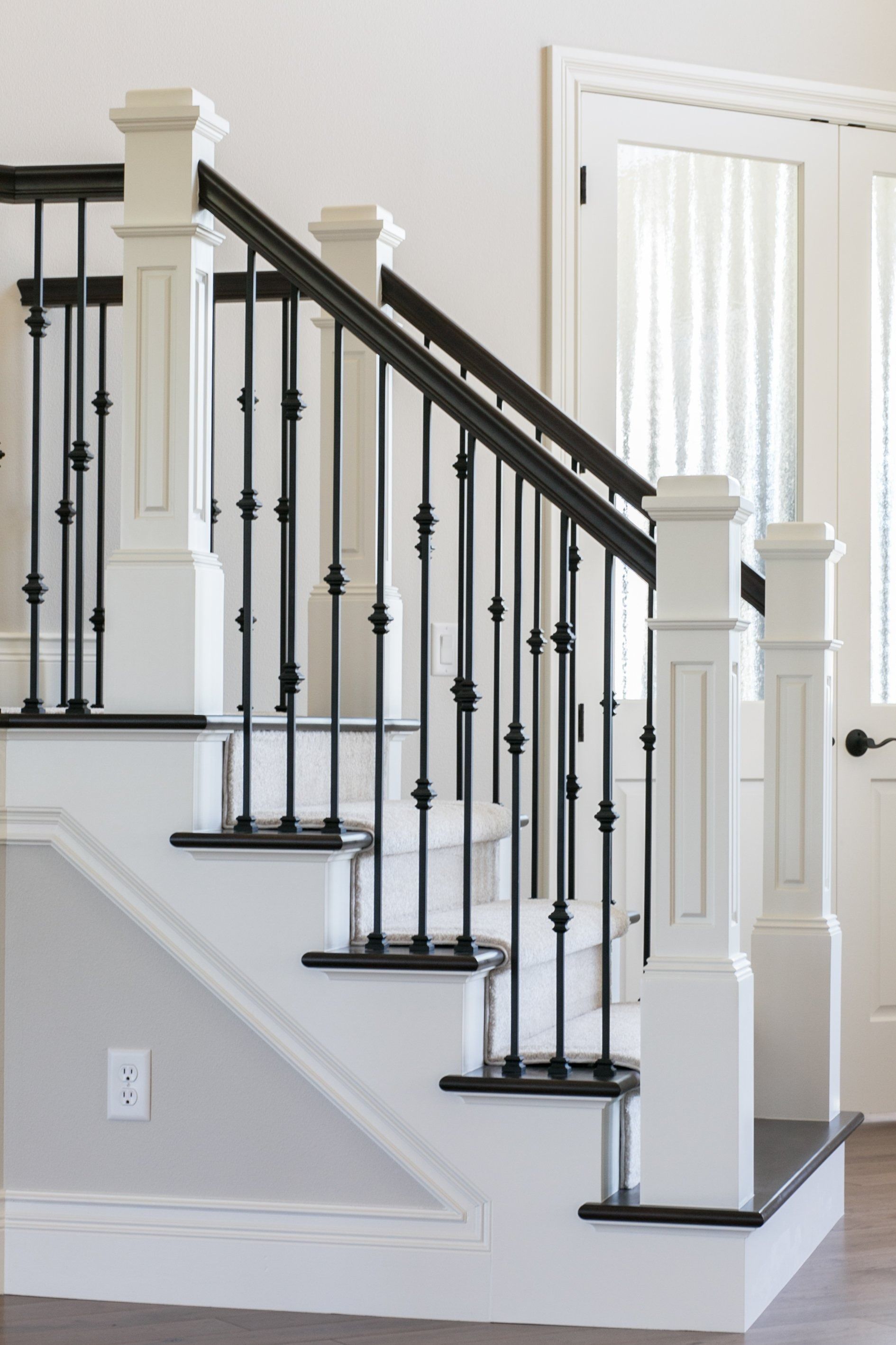 White staircase with black handrail and spindles; white newel posts.
