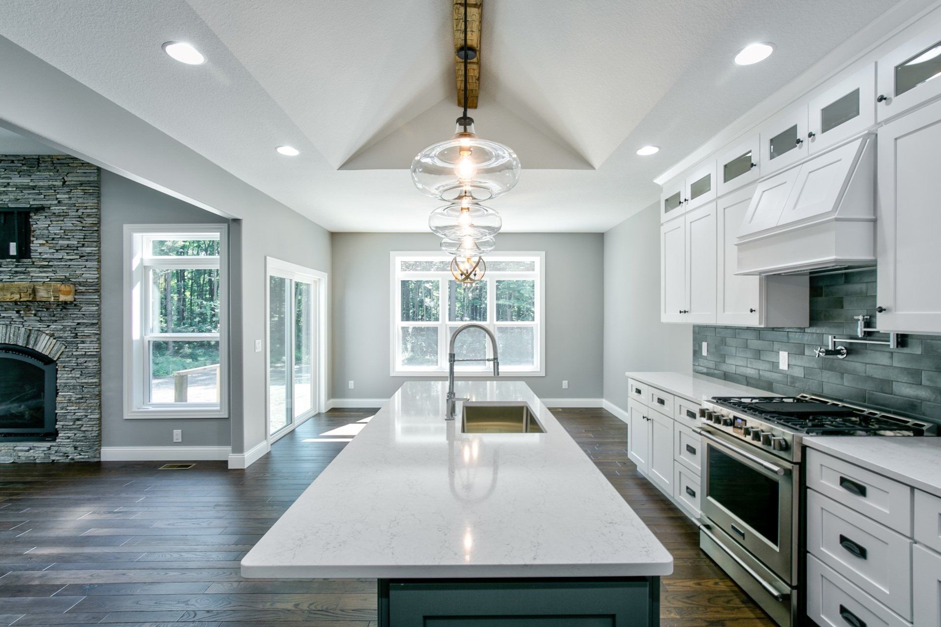 Modern kitchen with white cabinets, large island, and stainless steel appliances.