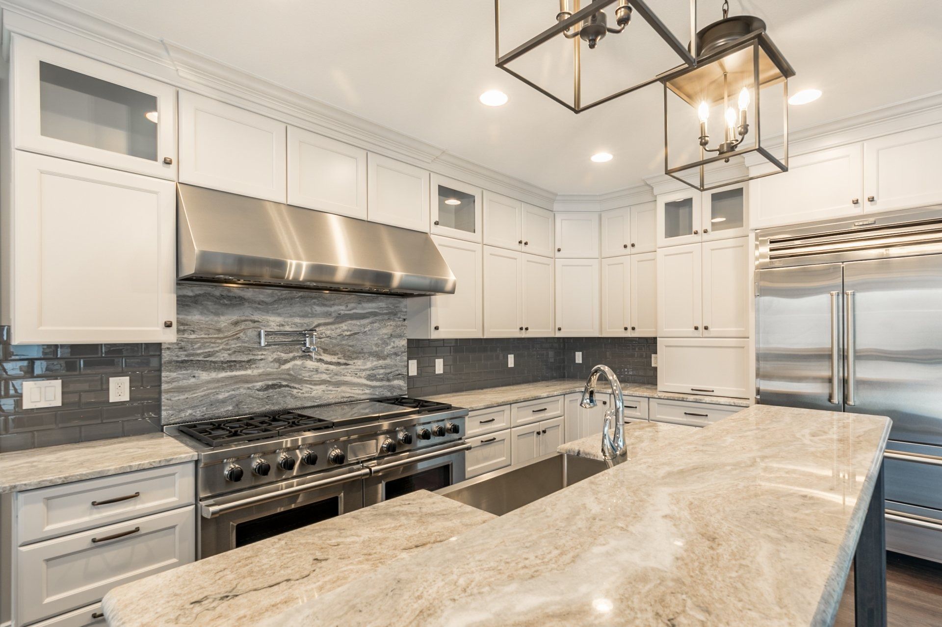 Modern kitchen with white cabinets, stainless steel appliances, and granite countertops.