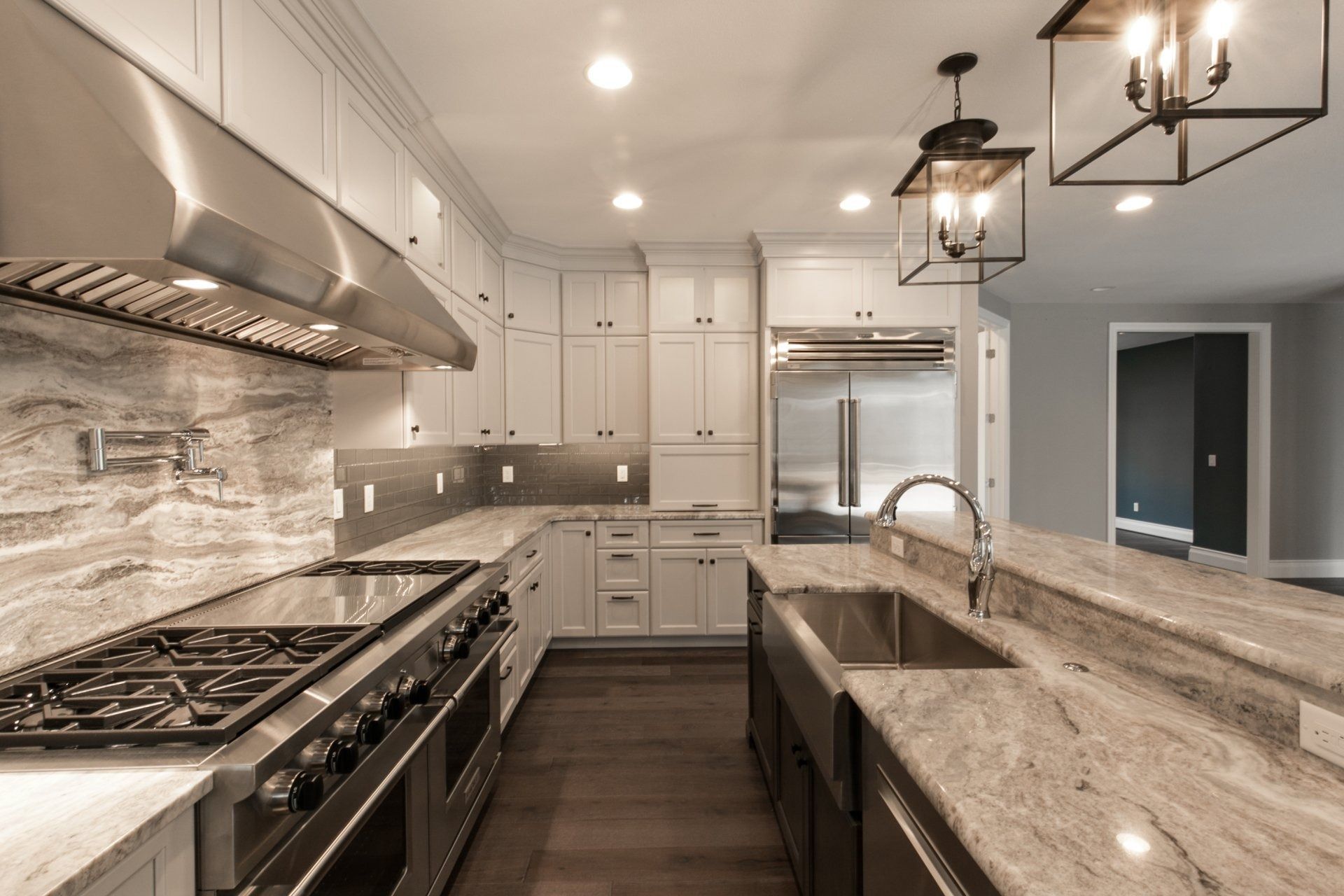 Modern kitchen with white cabinets, stainless steel appliances, and granite countertops.