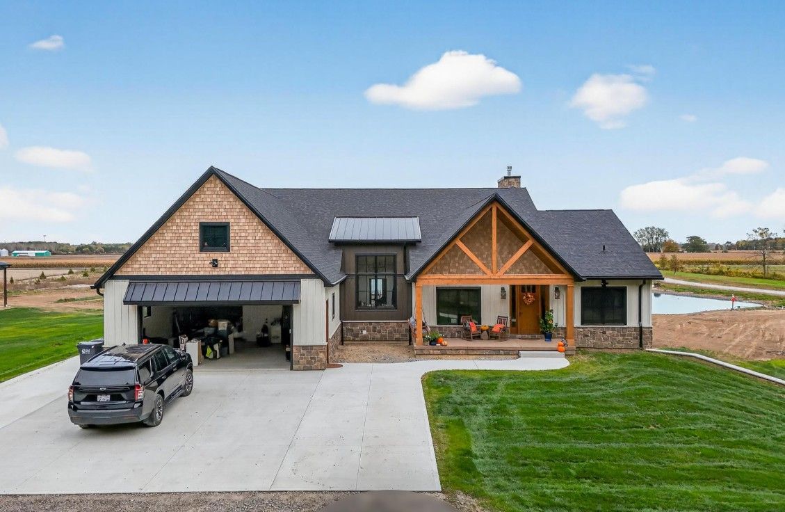 Modern farmhouse exterior with gray roof, wood accents, and attached garage.