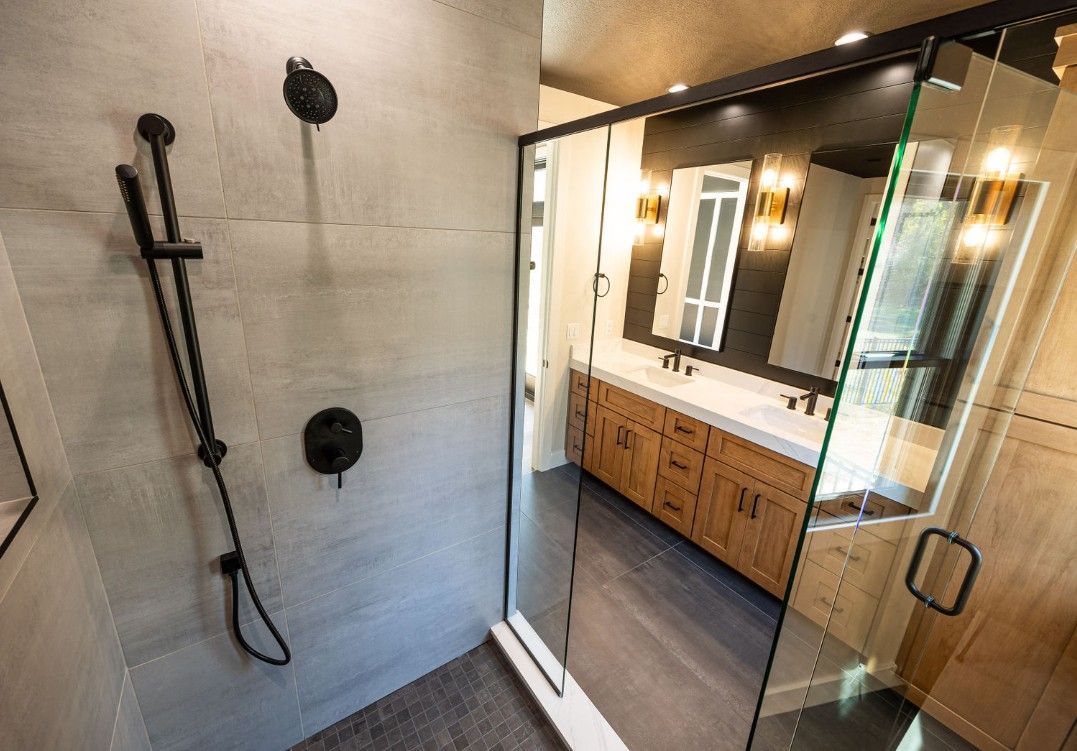 Modern bathroom: shower with black fixtures, glass door, vanity with wood cabinets.