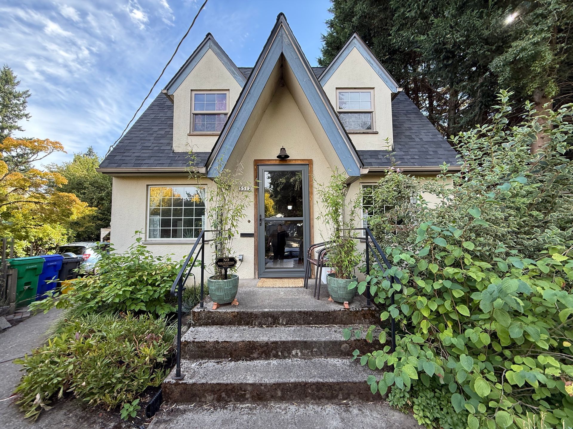 A storybook-style house with a steep roof, small windows, and a front porch.