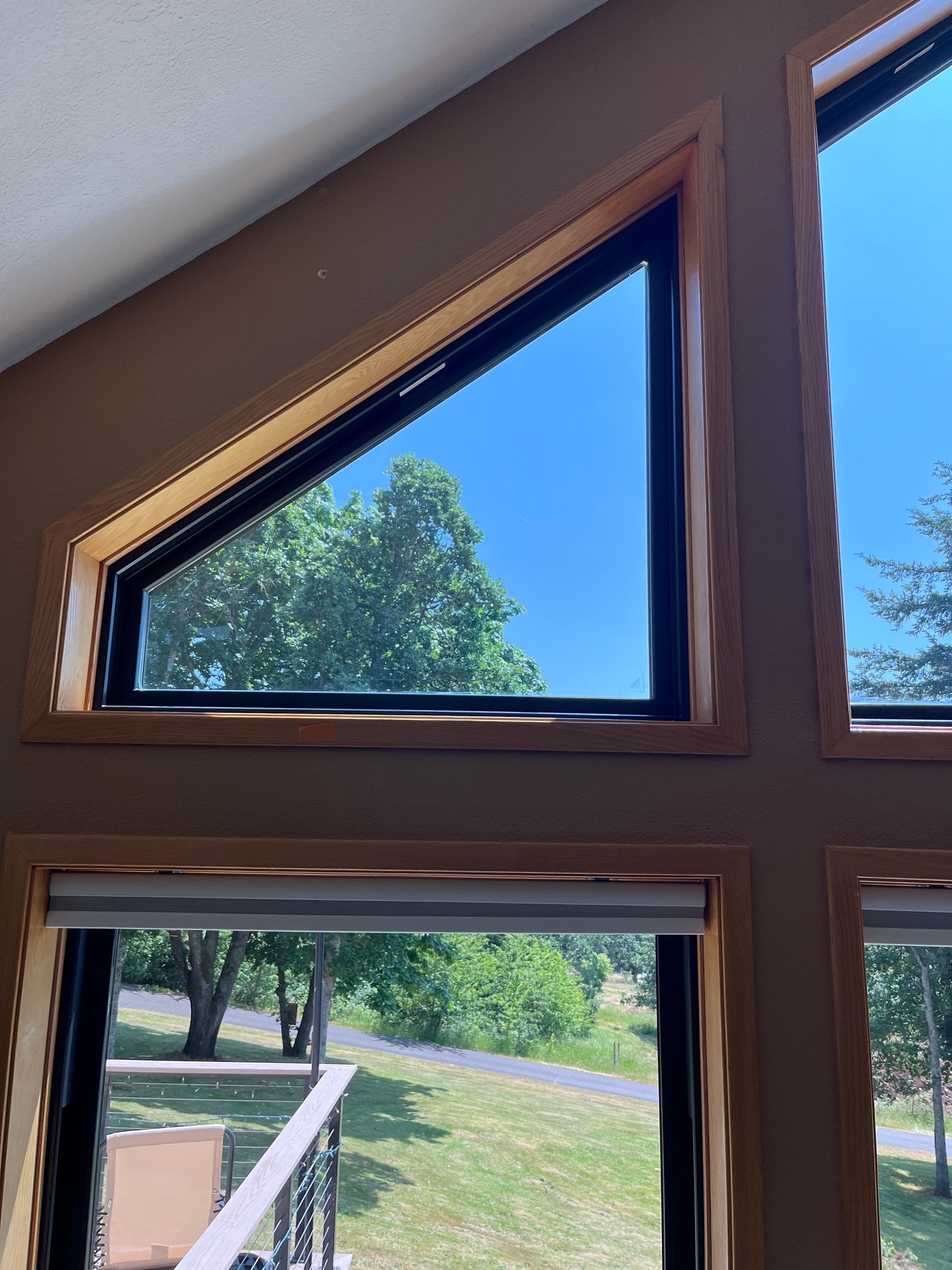 White-framed, two-pane sliding window installed on a teal-sided house, showing FlexWrap underneath.