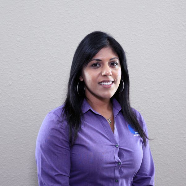 A woman in a purple shirt is smiling for the camera