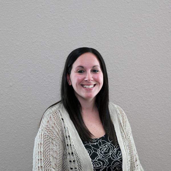 A woman in a white sweater is smiling for the camera.