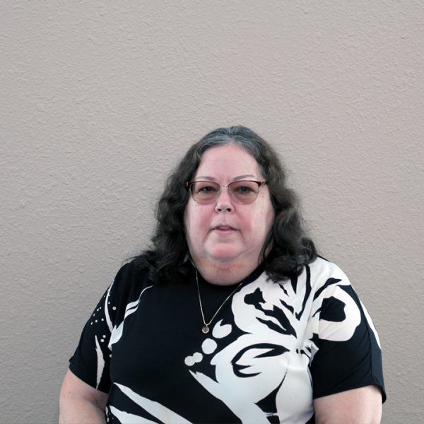 A woman wearing glasses and a black and white shirt