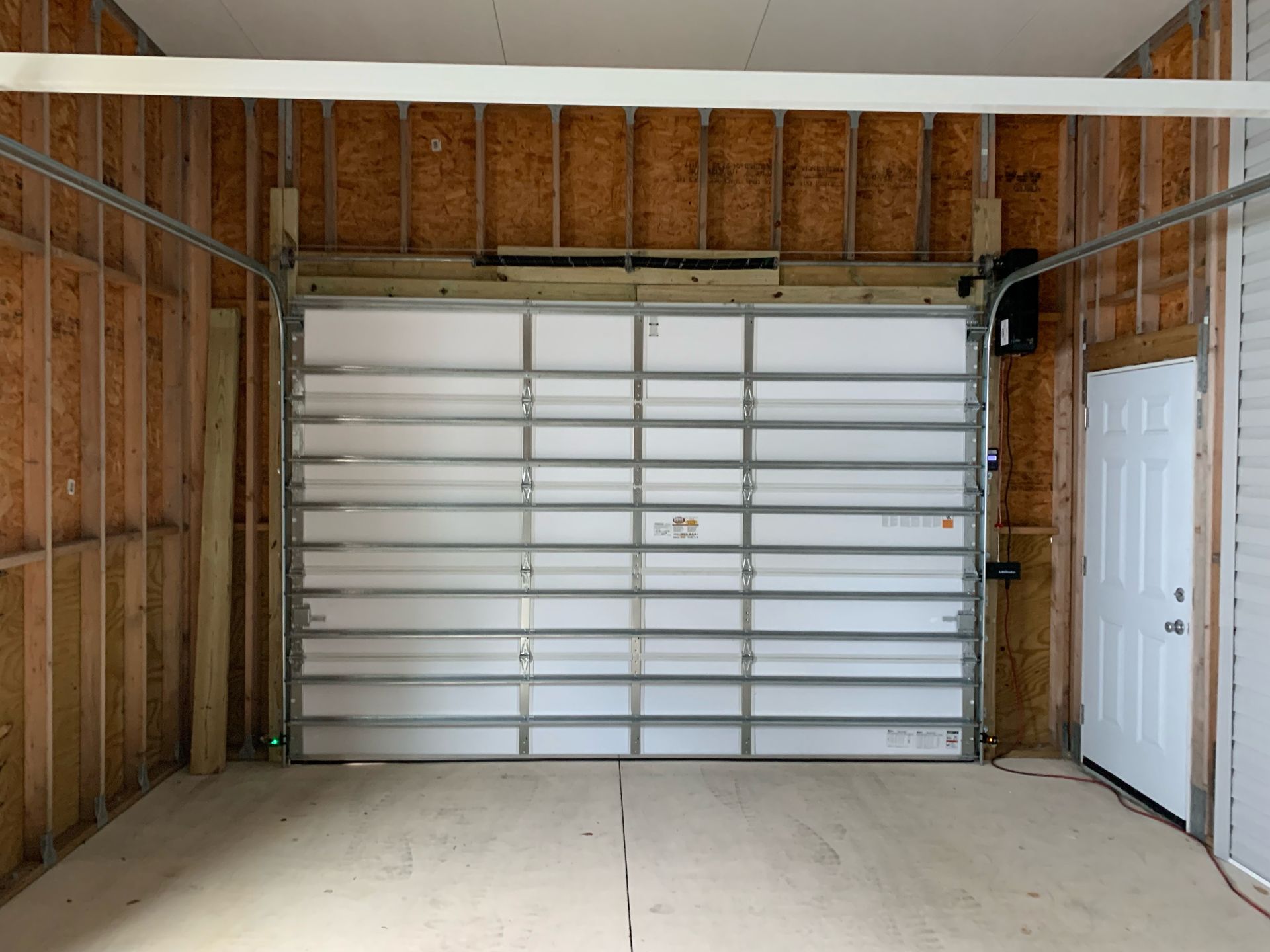 An empty garage with a garage door that is open