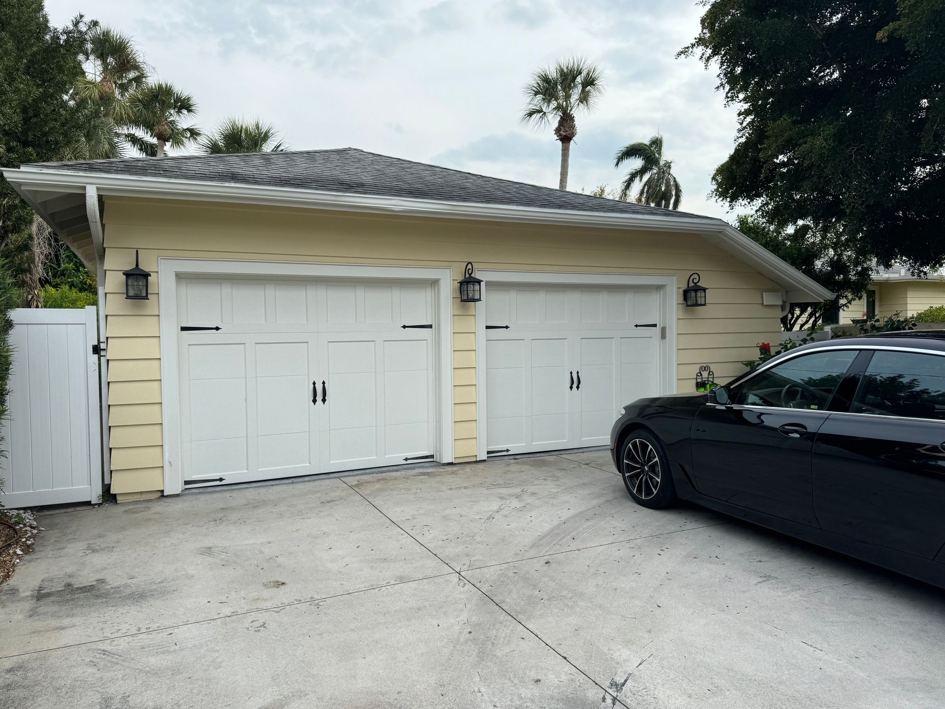 A black car is parked in front of a garage
