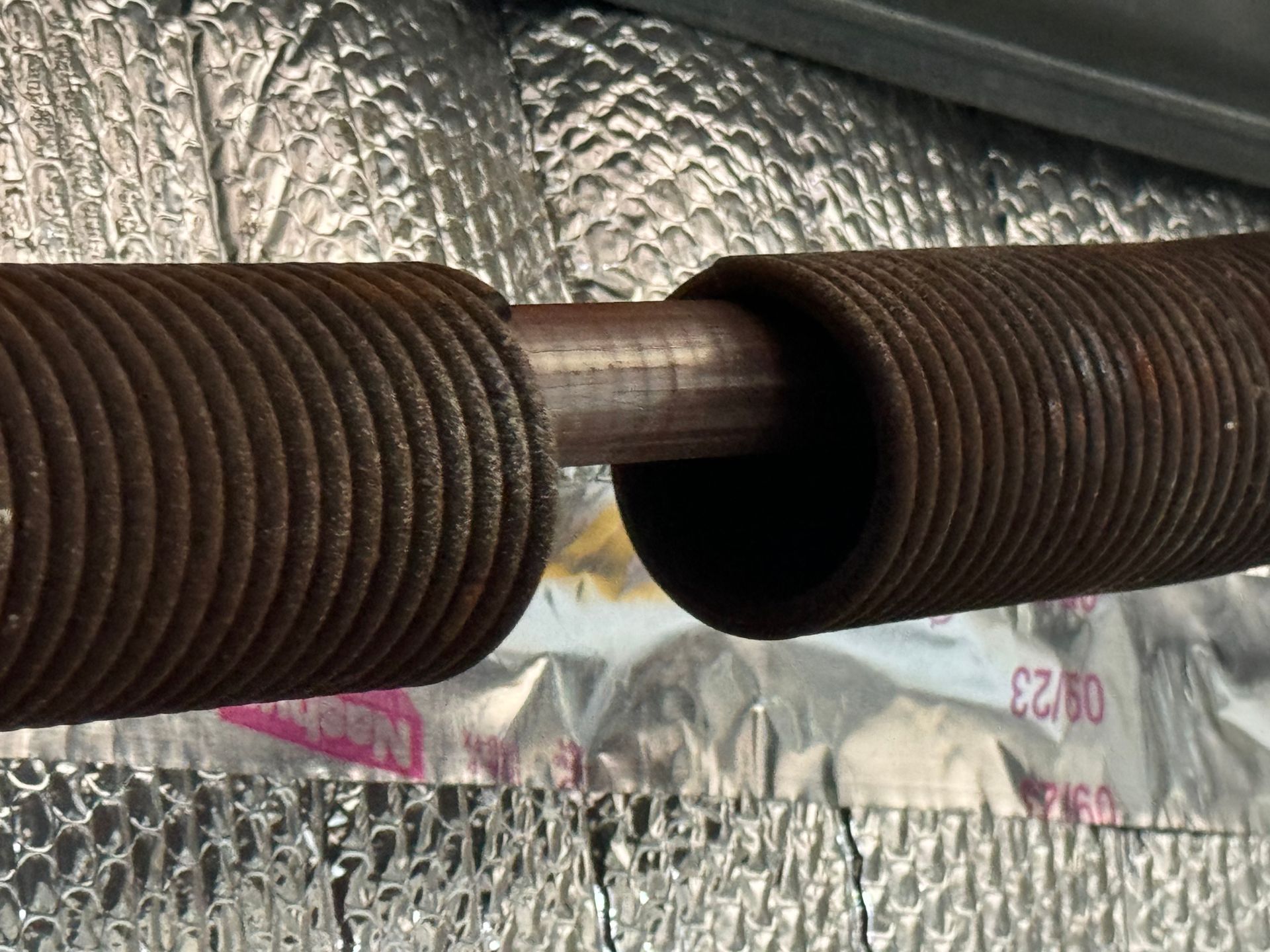A close up of a garage door spring on a piece of foil