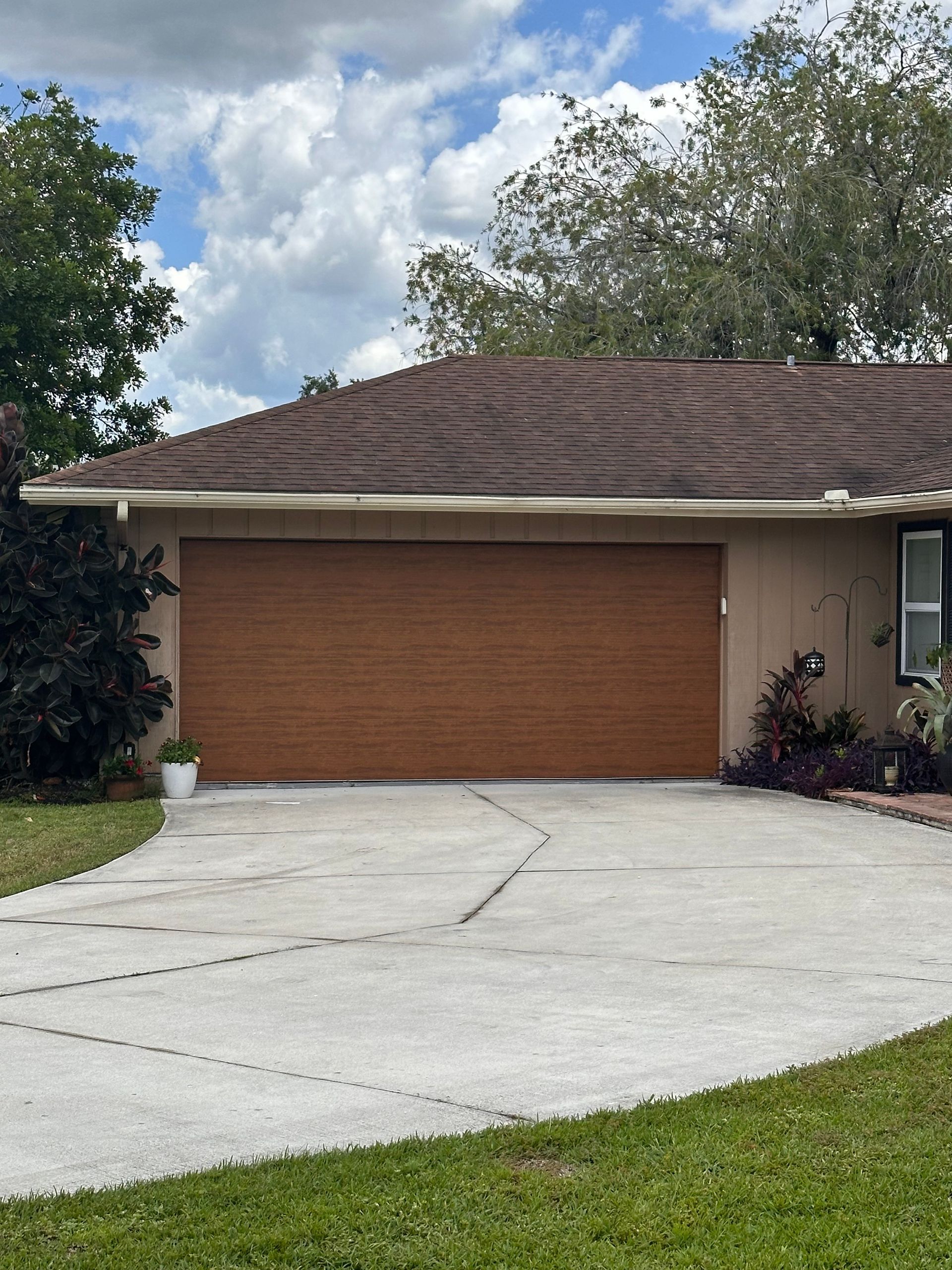 A house with a brown garage door and a concrete driveway