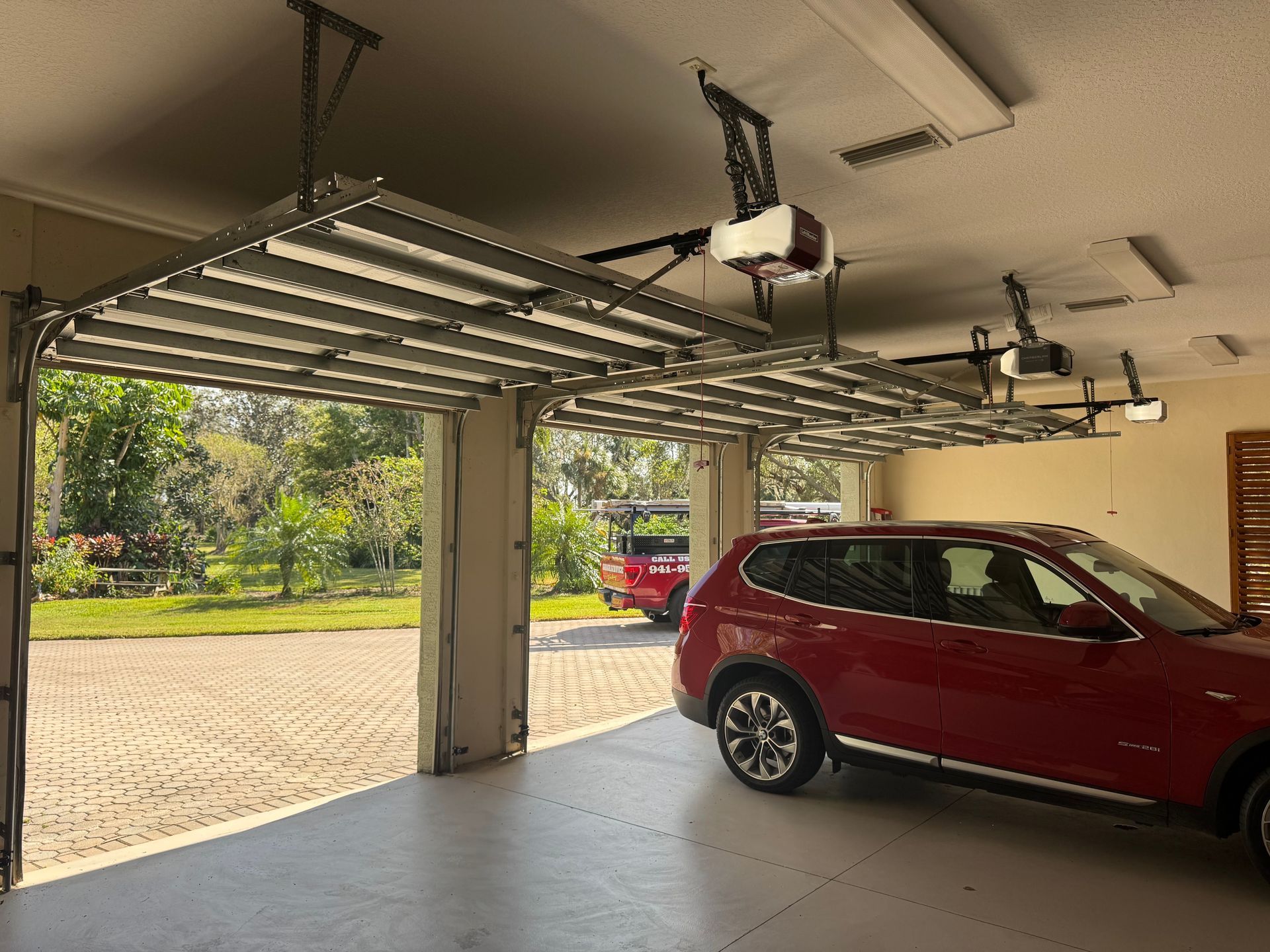 A red suv is parked in a garage with the door open.