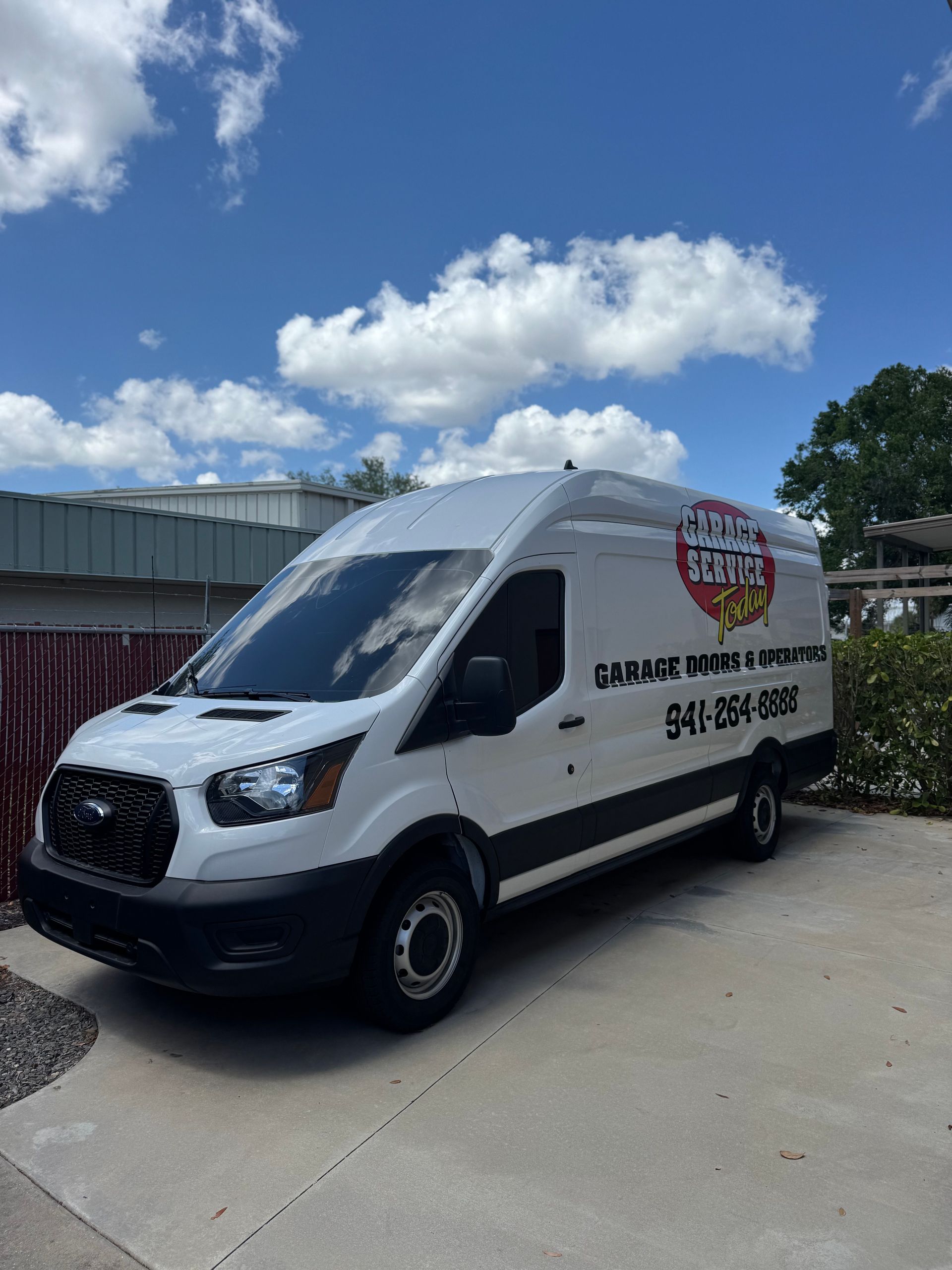 A white van is parked on the side of the road.