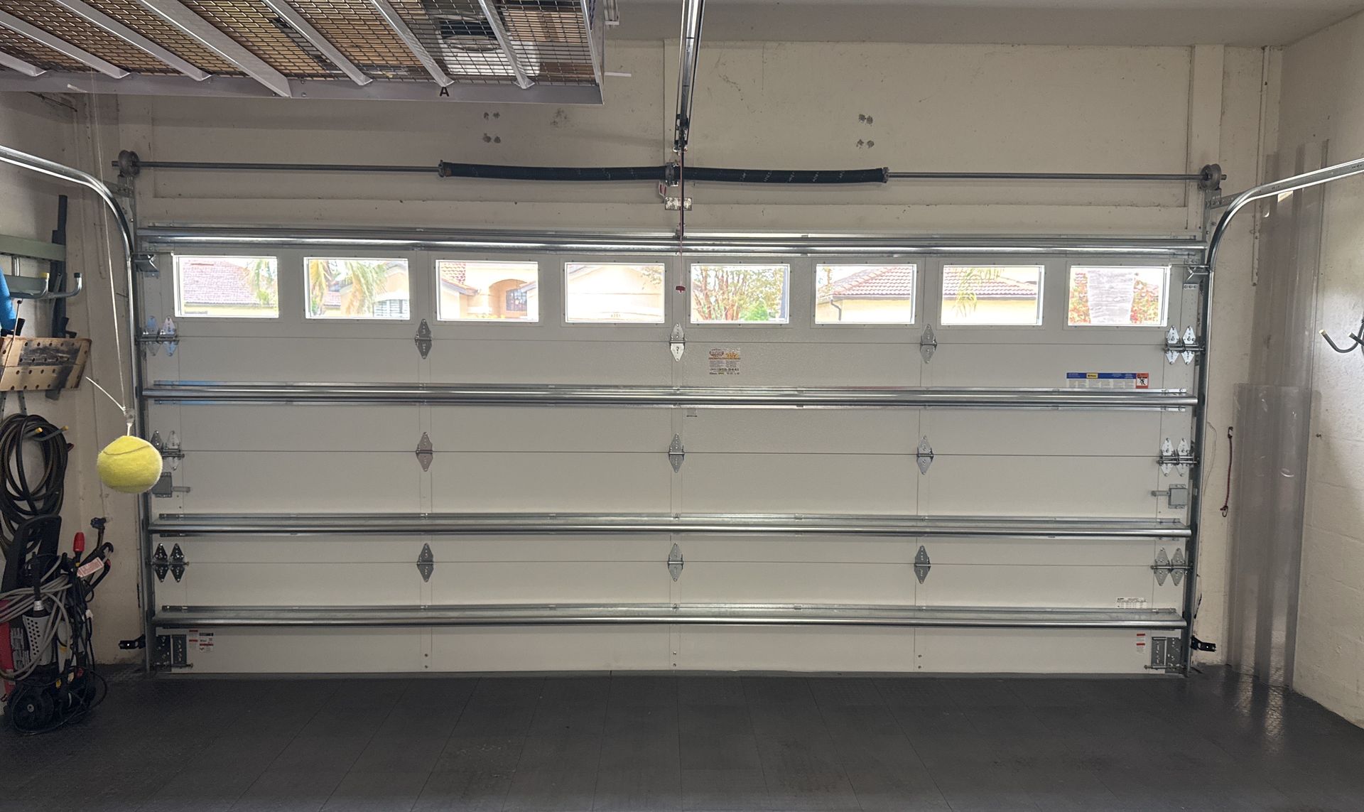 A garage with a white garage door and a gray floor.