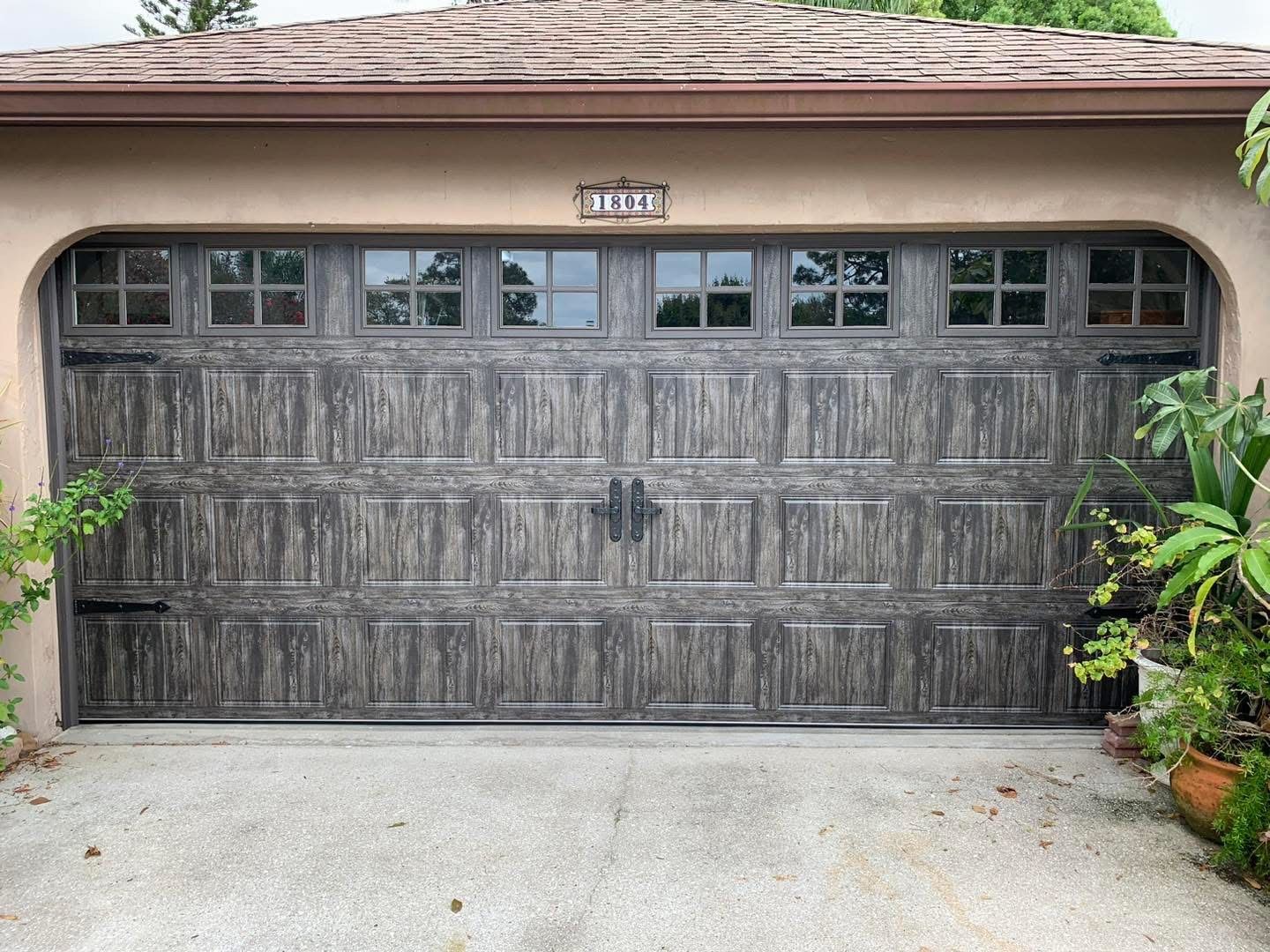 A large wooden garage door is sitting in front of a house.