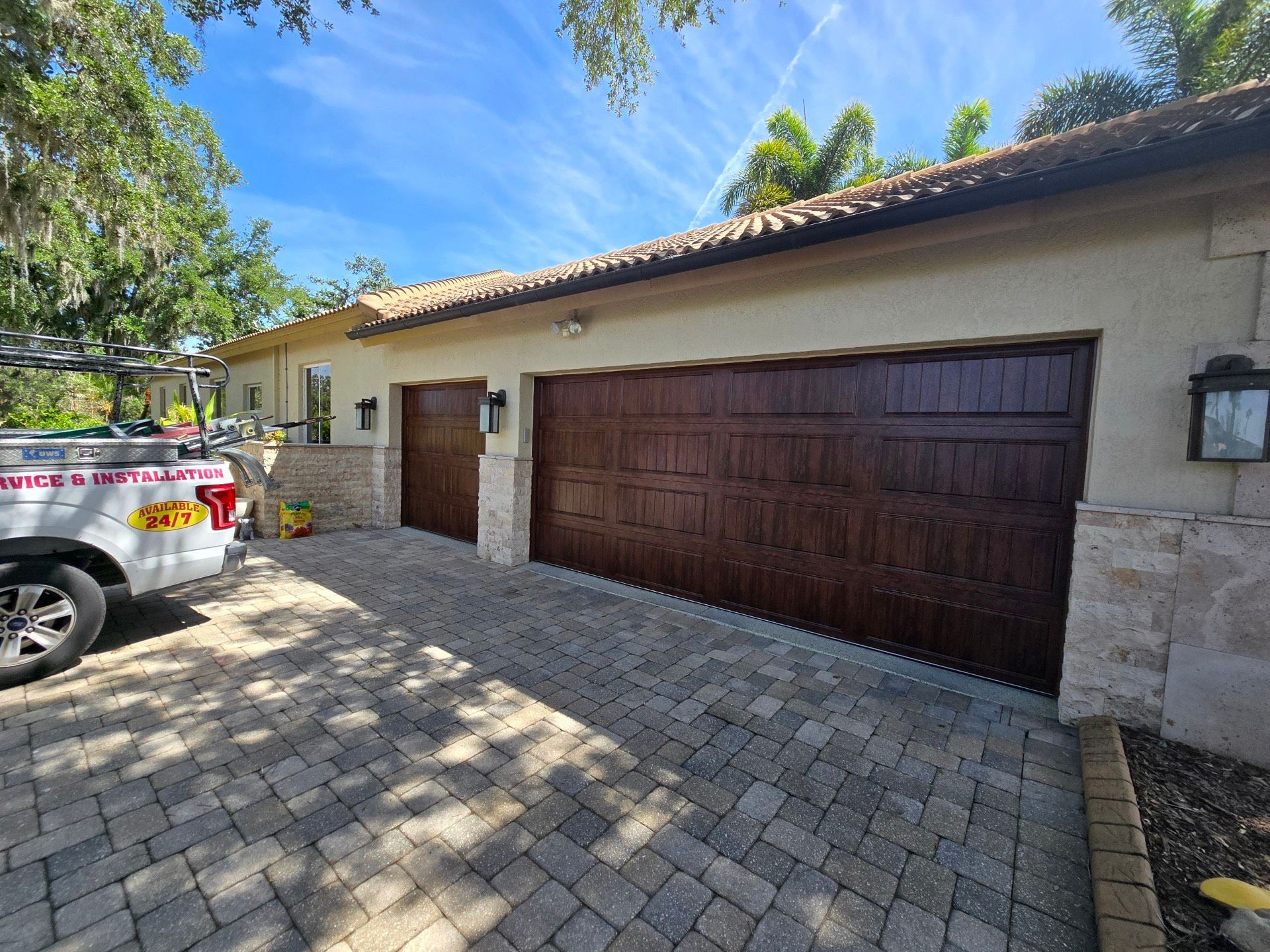 A white truck is parked in front of a large garage door.