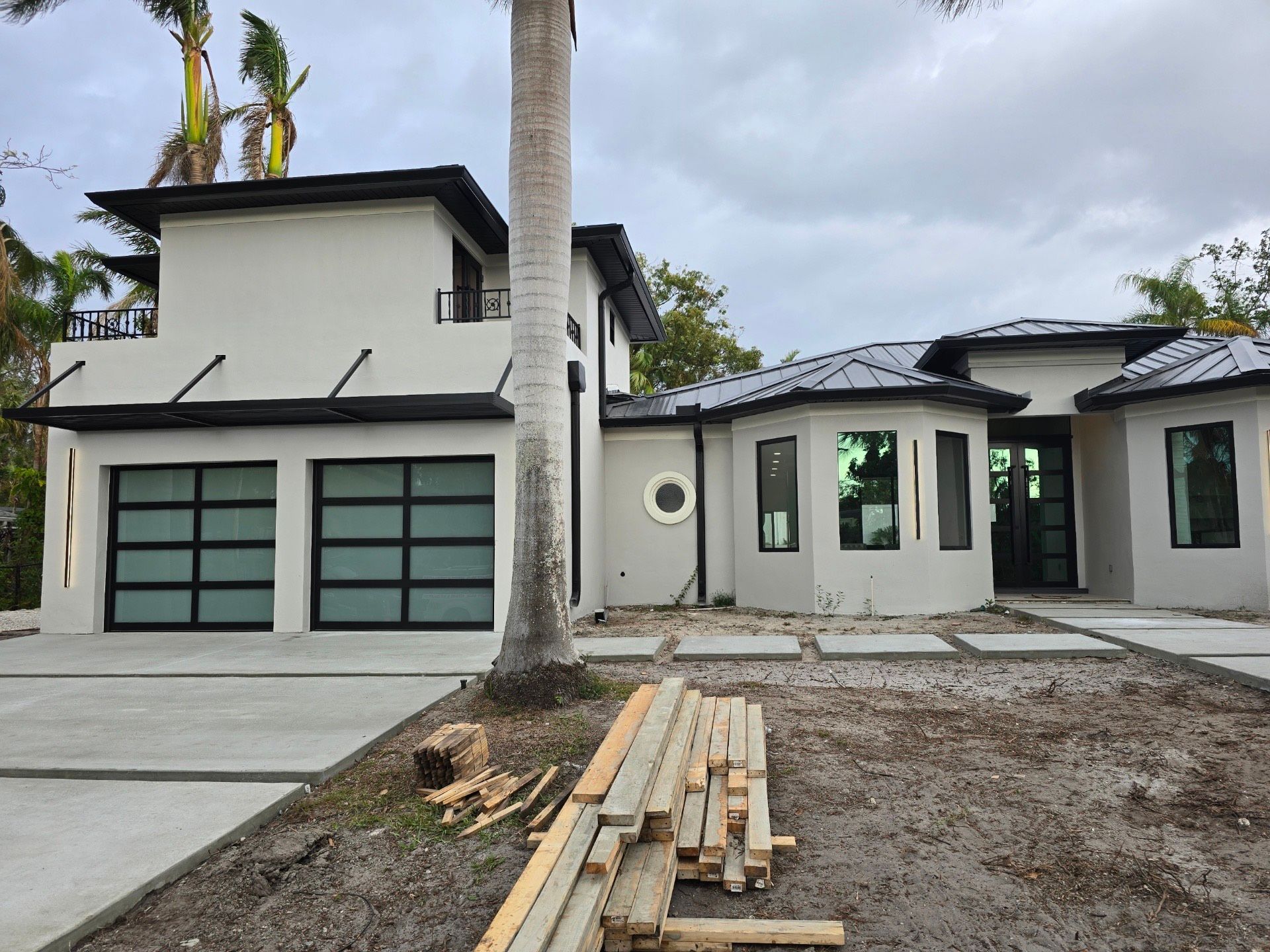 A white house with black garage doors is under construction