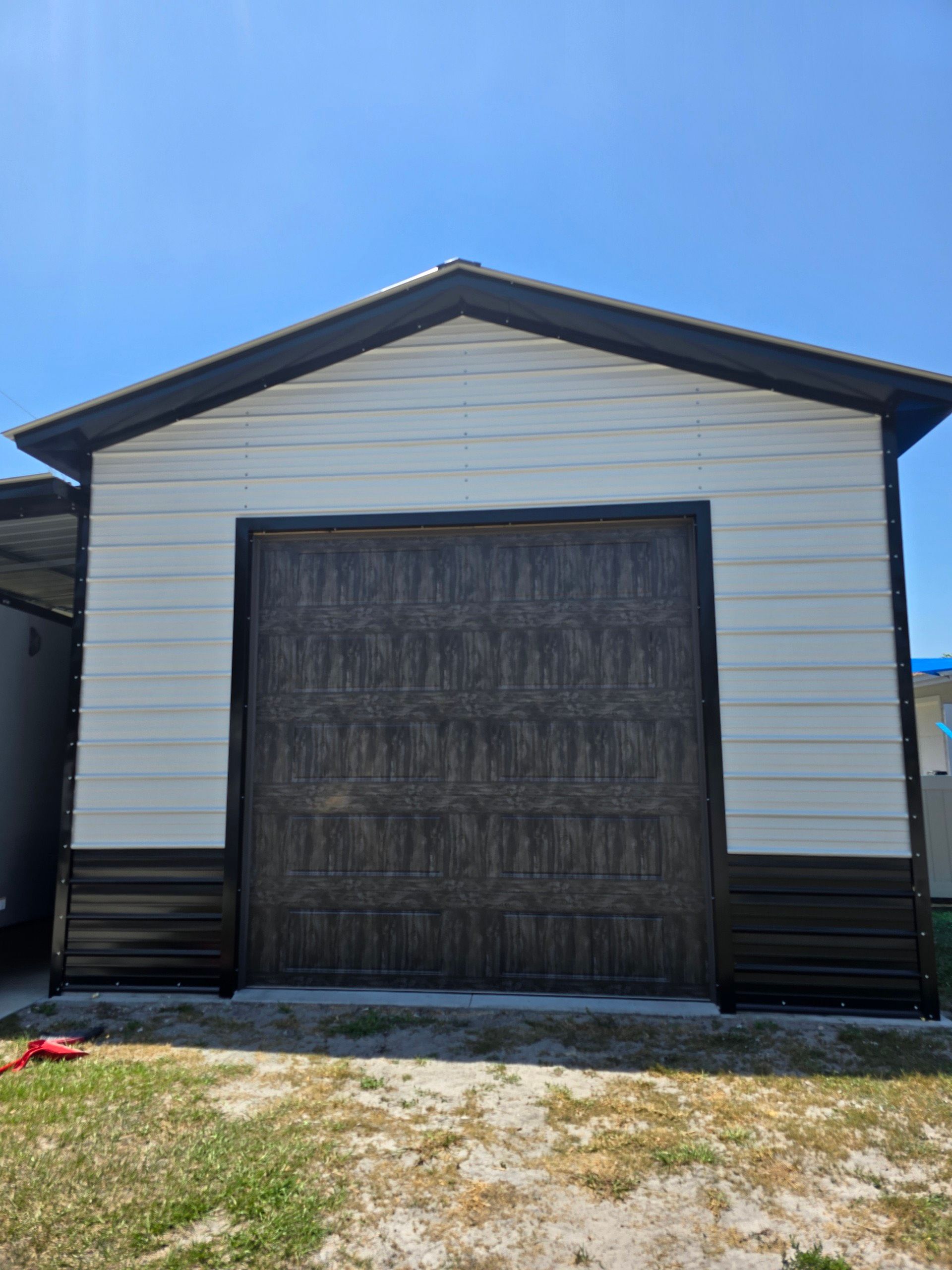 A white and brown garage with a large garage door.