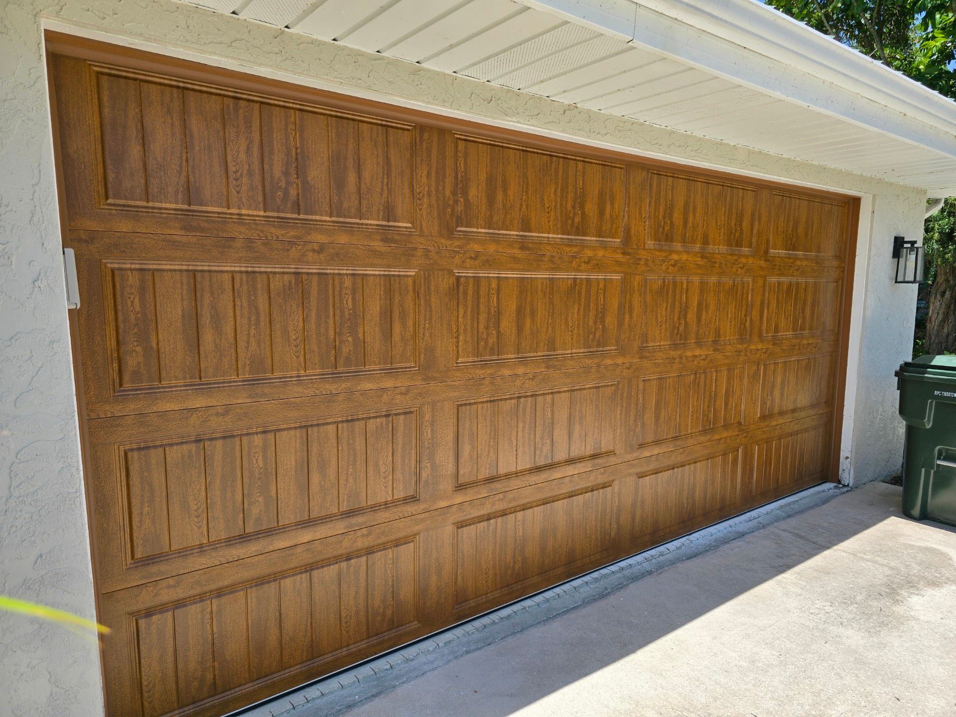 A large wooden garage door is sitting on the side of a house.