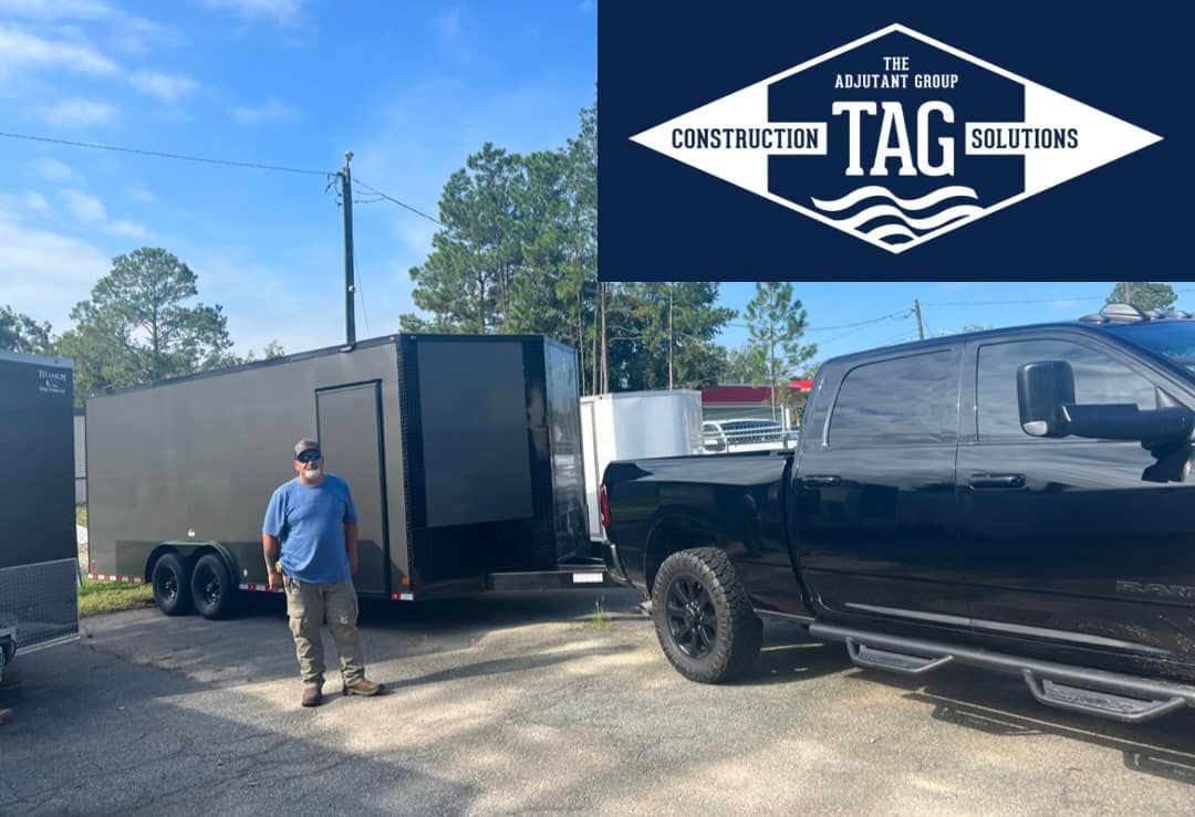 A man is standing next to a truck with a trailer attached to it.