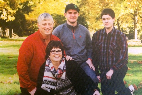 A family is posing for a picture in a park.