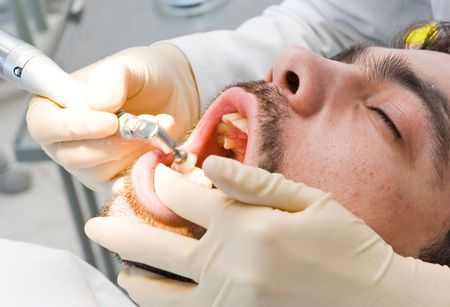 A man is getting his teeth examined by a dentist