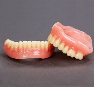 A pair of dentures are sitting on top of each other on a table.