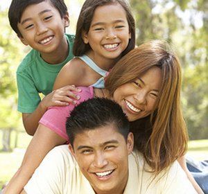 A group of children are sitting on top of a man.