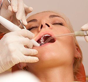 A woman is getting her teeth examined by a dentist.