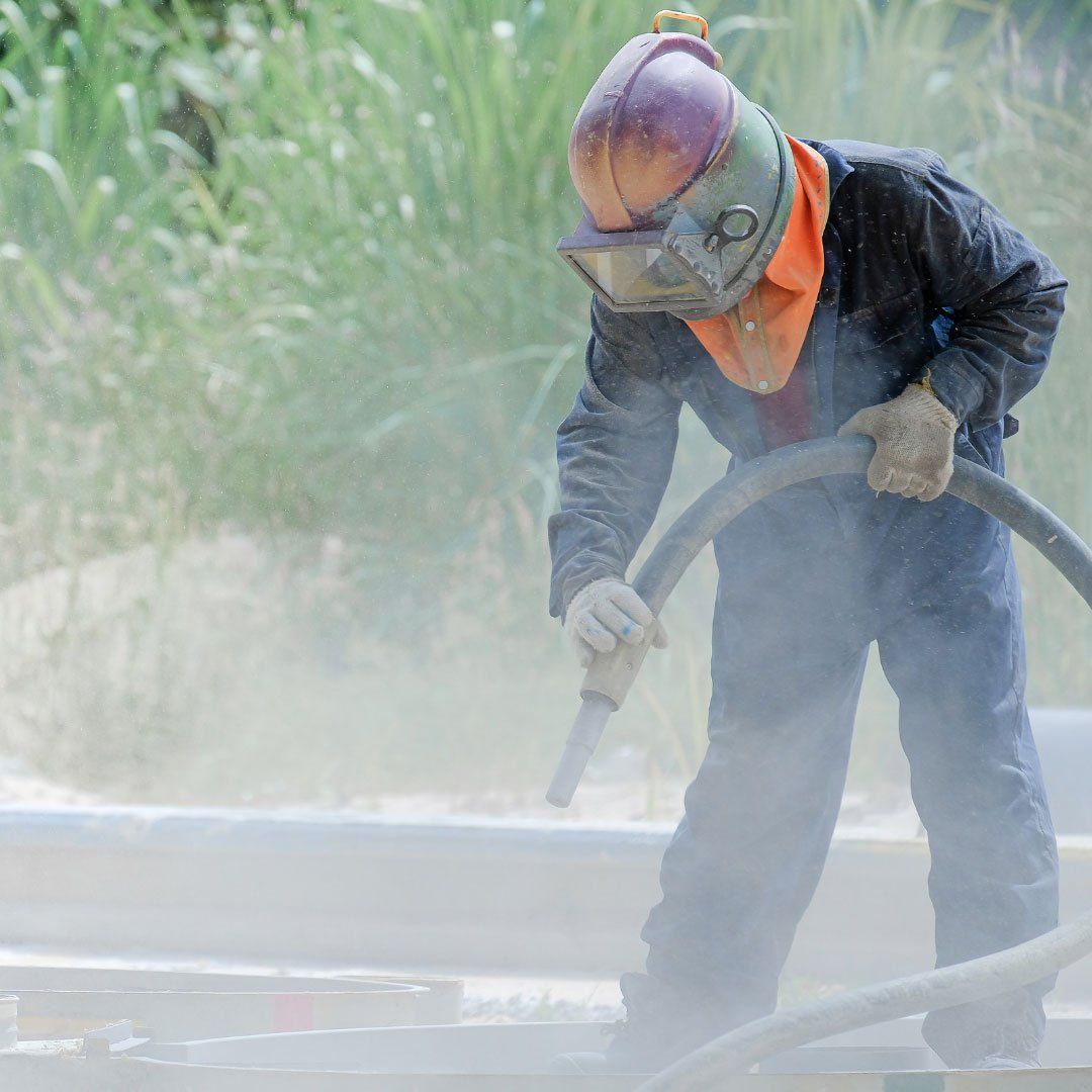 crew sandblasting the metal parts