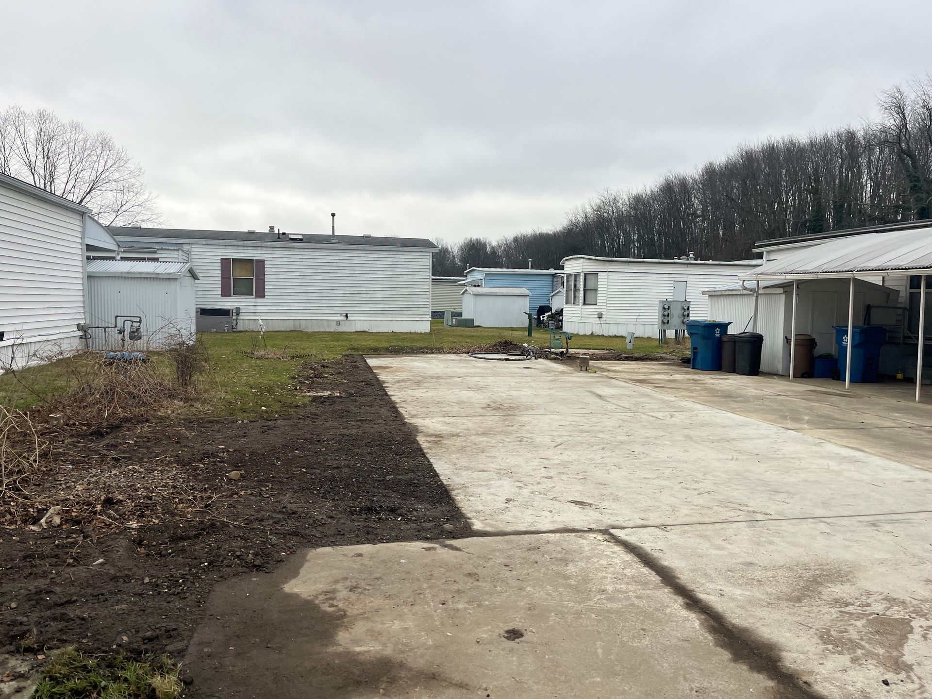 Concrete pad and mobile homes in a cloudy outdoor setting.