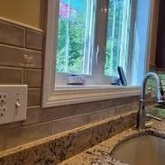 Kitchen window with faucet, sink, and tiled backsplash.