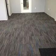 Room with gray, blue, and black patterned tile flooring. A door is visible in the center.