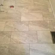Bathroom wall tiled with rectangular, light gray tiles.