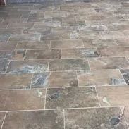 Slate tile floor in shades of brown, gray, and blue with grout lines.