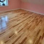 Light wood floor in a room with pink walls, near a window.