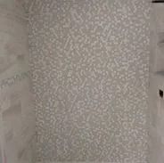 Gray and white patterned wallpaper covering a wall.
