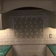 Kitchen backsplash with decorative tile and under-cabinet lighting.