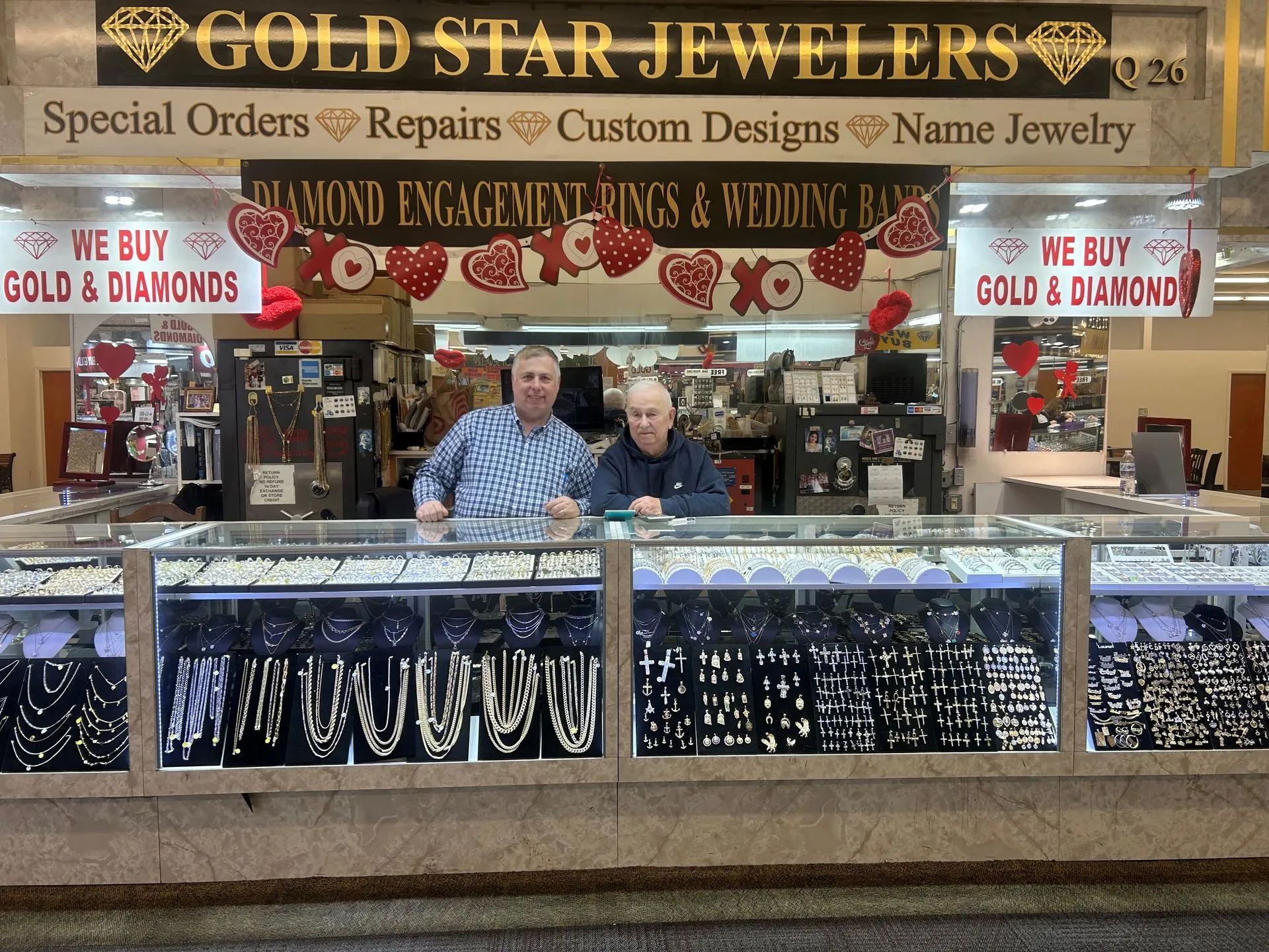 Two men are behind the counter at gold star jewelers.