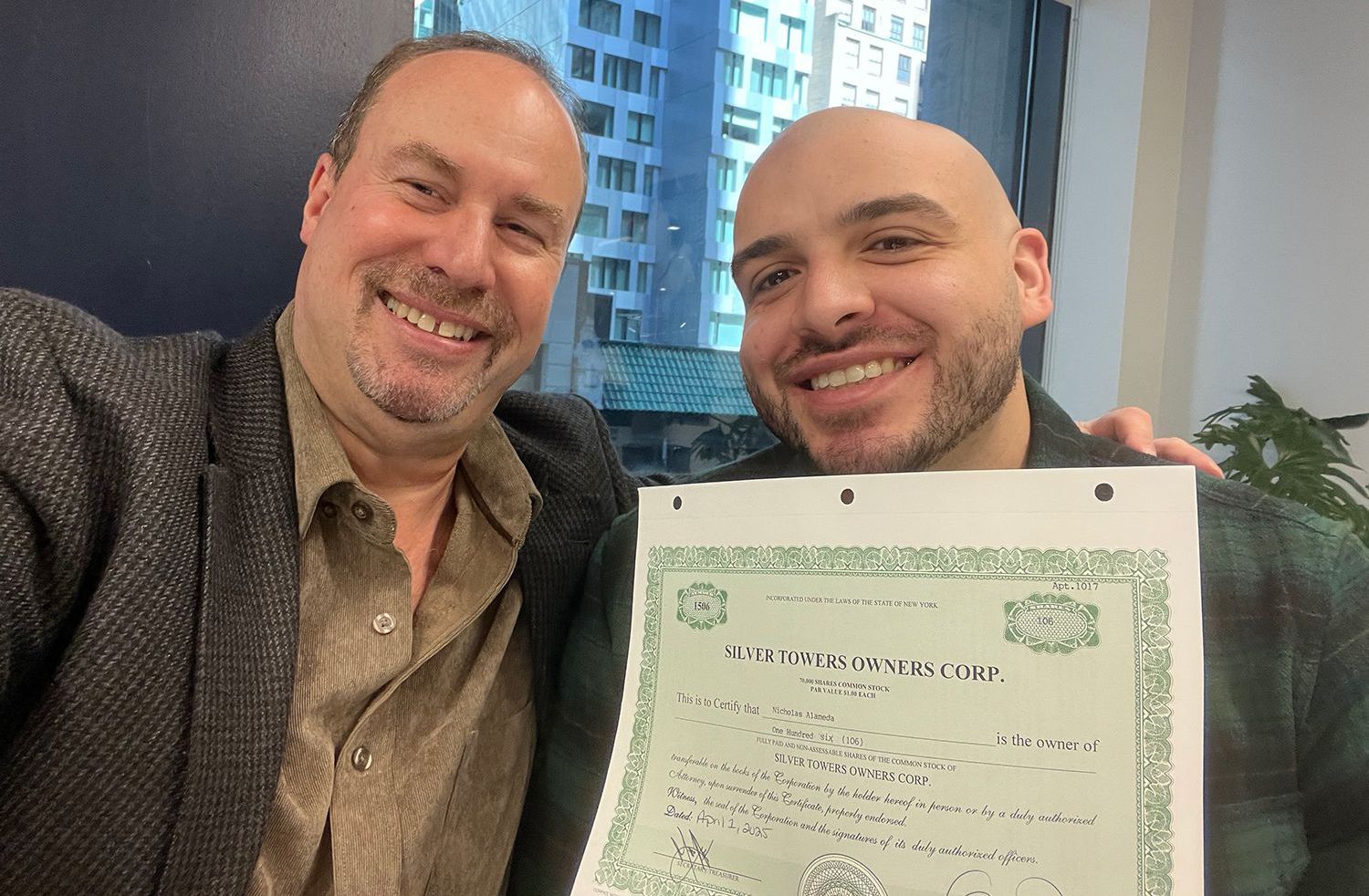 Two men are posing for a picture while holding a certificate.