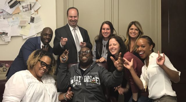 A group of people are posing for a picture in a room.