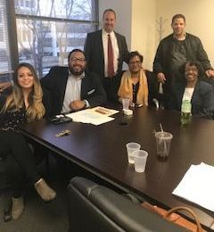 A group of people are sitting around a table in a conference room.